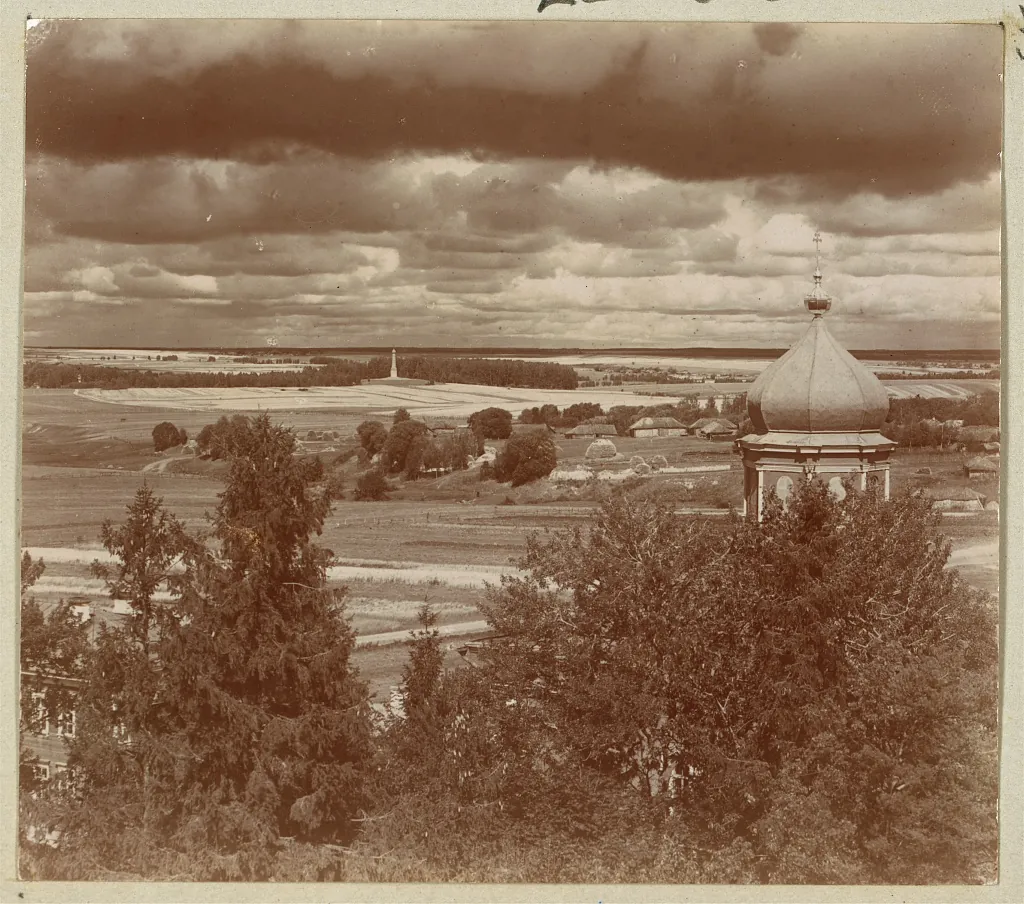 Photographie ancienne d'une vaste plaine vue depuis une galerie de monastère, avec au loin la hauteur de la batterie Raïevski