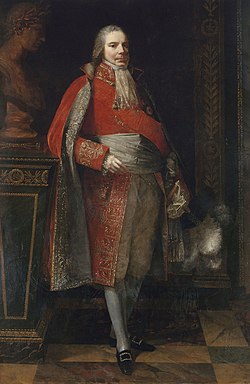 Portrait en pied de Charles-Maurice de Talleyrand-Périgord en habit écarlate de grand chambellan brodé d'or, large sash gris-argent et cravate de dentelle blanche, jambes croisées, appuyé au coude sur un piédestal en marbre vert sommé d'un buste antique lauré ; intérieur aux boiseries — peinture de Pierre-Paul Prud'hon (1807), musée Carnavalet, Paris