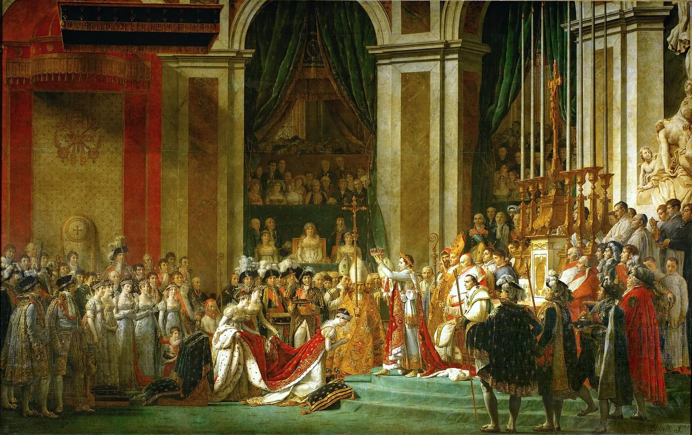 Dans une cathédrale bondée, un empereur en manteau de velours rouge brodé d'or élève une couronne au-dessus d'une femme agenouillée devant lui