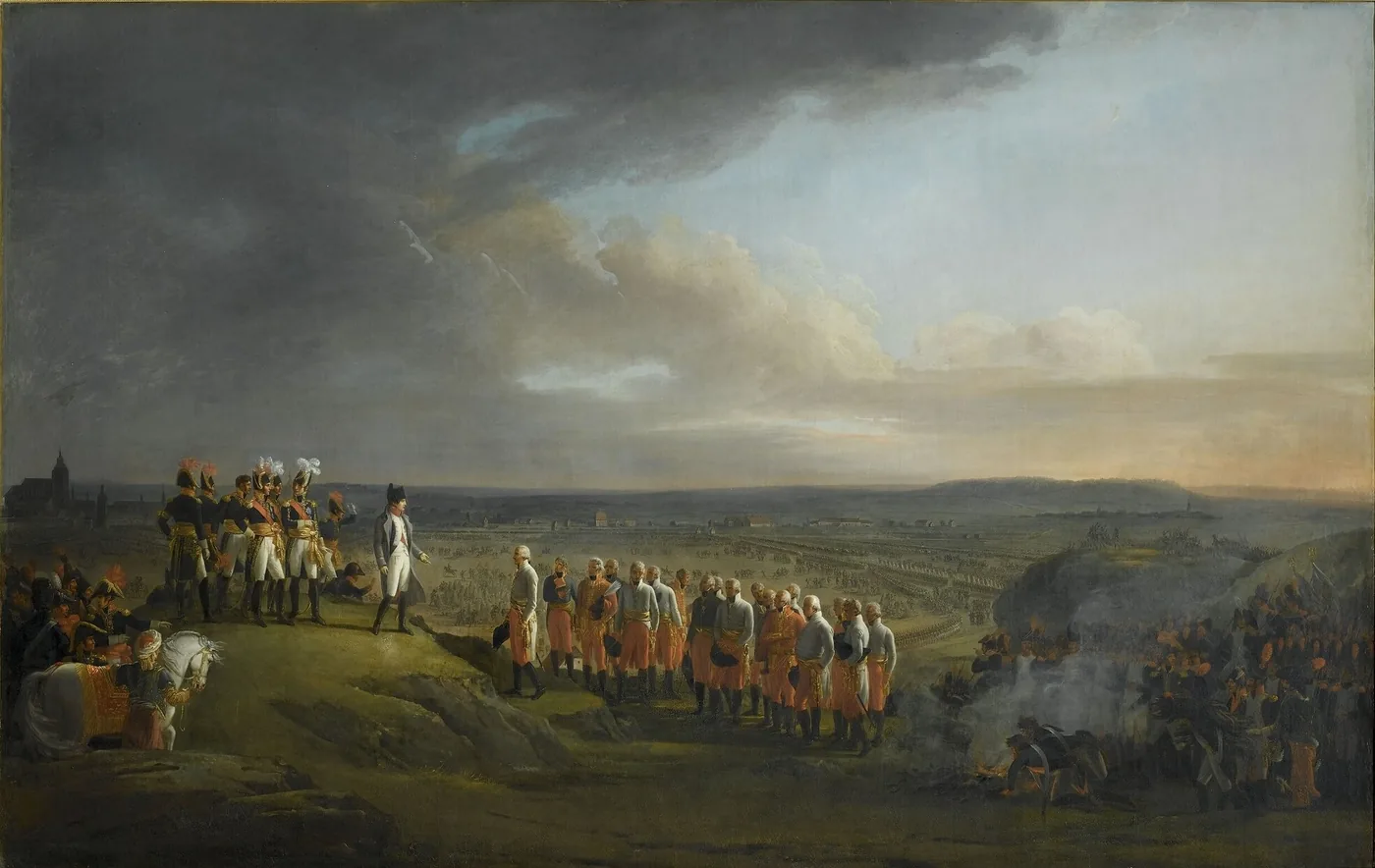 On a height overlooking a vast plain where the army is deployed, Napoleon in a grey greatcoat, surrounded by marshals in full dress, faces a group of Austrian officers in white uniforms who have come to surrender; on the left, the spires of Ulm on the horizon